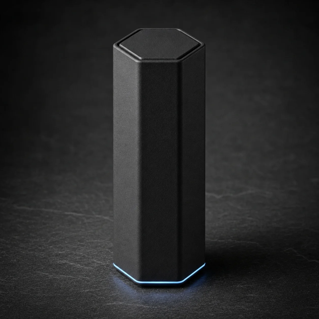 Overwatch Node, a tall slim matte black hexagonal local AI server with a thin blue light at its base